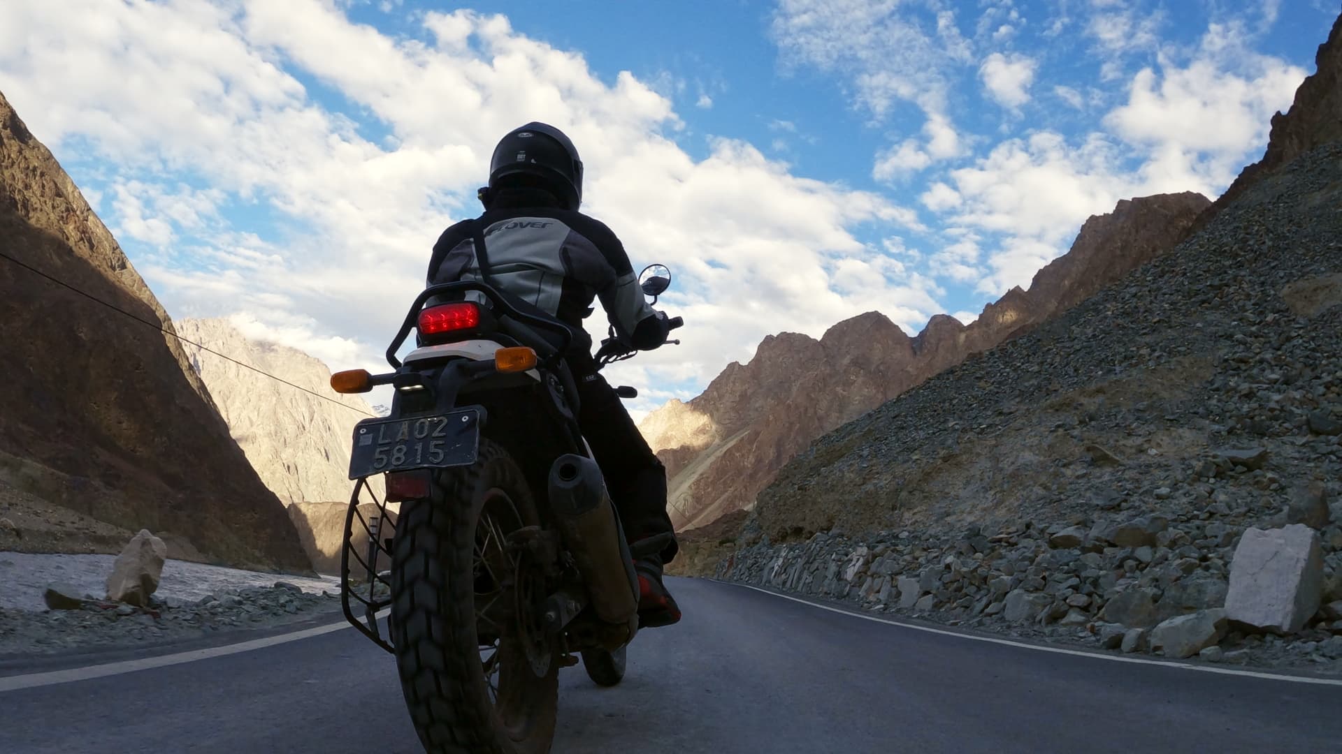 Rider on the road toward distant peaks