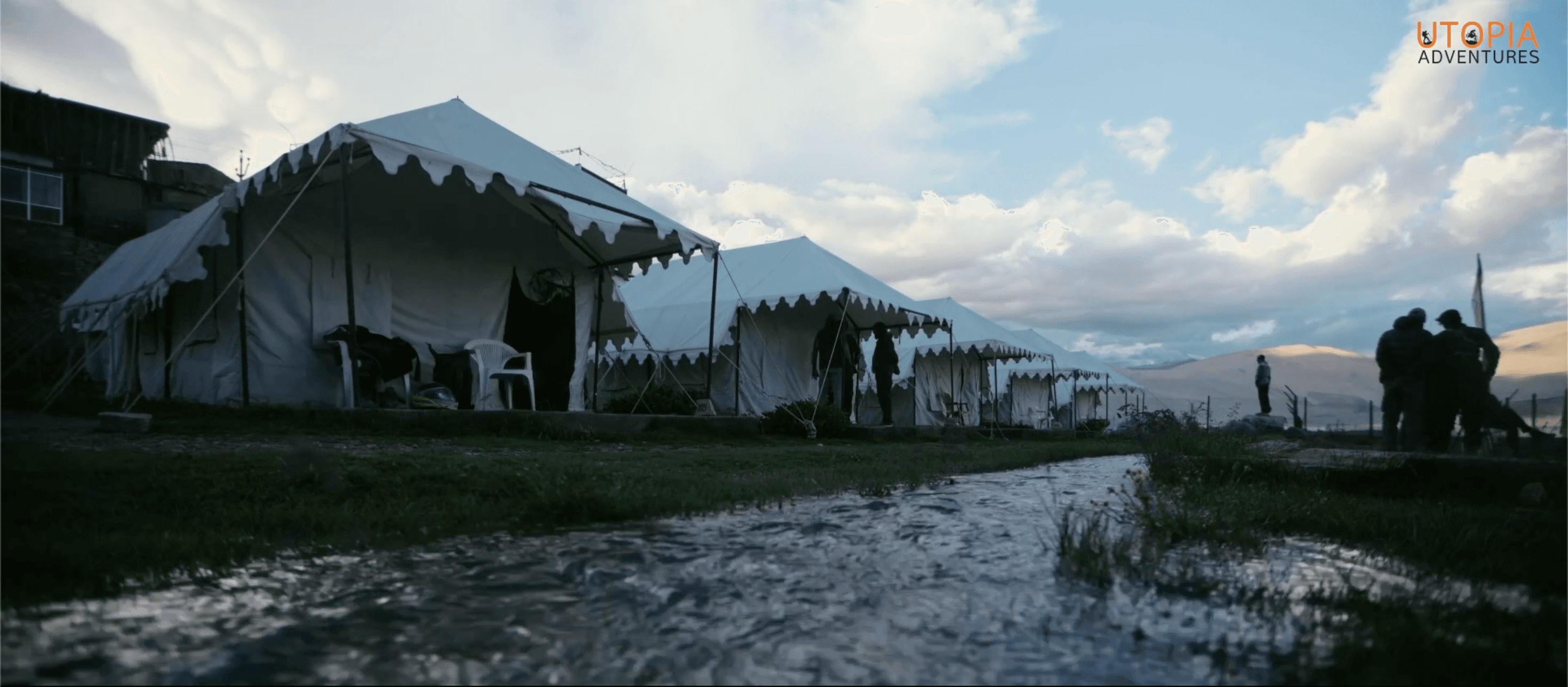 Glamping tents beside a stream